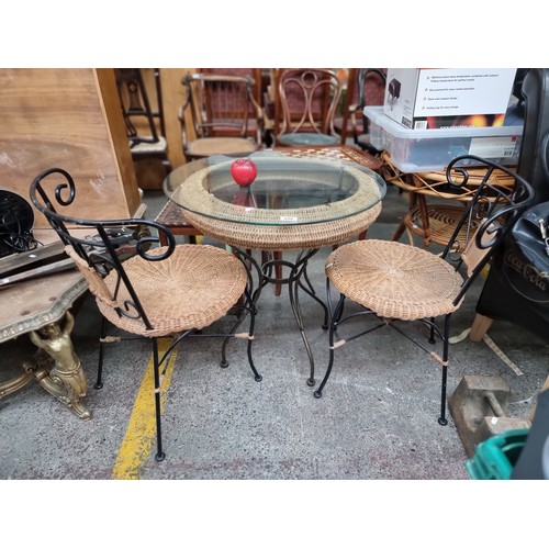 600 - A stylish two seater patio set with glass top table and two matching wicker chairs. In very good con... 