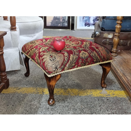 632 - An elegant antique Victorian footstool, set on cabriole mahogany legs and upholstered in a floral ta... 