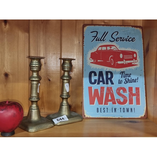 644 - An elegant pair of brass candlestick holders, paired with a vintage-inspired metal car wash sign, ad... 