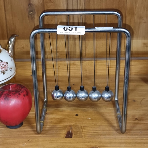 A super vintage Newton's Cradle, a classic desk accessory demonstrating physics, with a sleek metallic finish and robust construction.