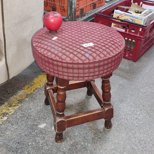 661 - A charming vintage wooden stool, upholstered in a burgundy checkered fabric, held on nicely turned l... 