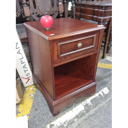 665 - A bedside locker, with a classic brass handle and elegant lines.