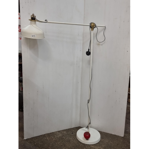 677 - An articulated cream floor lamp with a mid-century modern flair with brass accents and good quality ... 