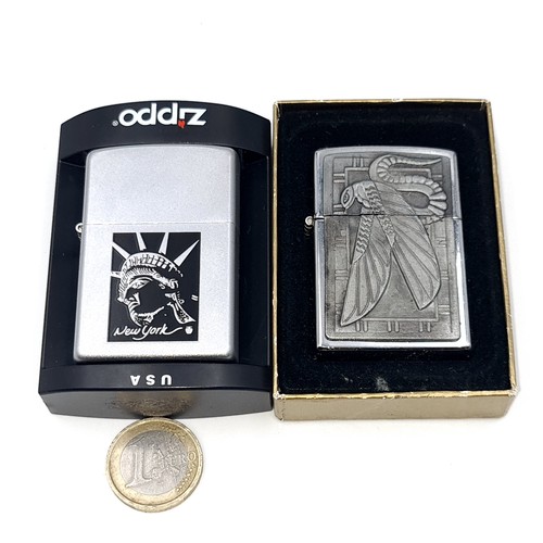 569 - Two unused Zippo lighters featuring a geometric mounted lighter together with a statue of liberty ex... 