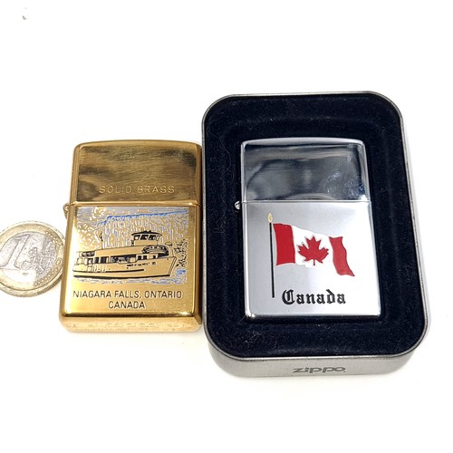 575 - Two unused Zippo lighters. The first with a mounted Canadian Flag. Also a solid brass Niagara Falls,... 