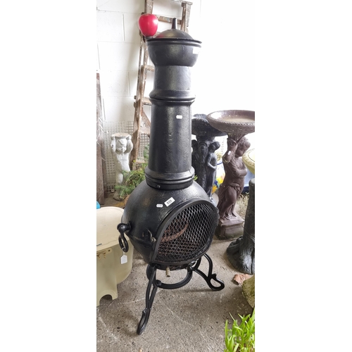 935 - A large black  cast iron chimney, featuring a classic round belly and an ornate mesh door, perfect f... 