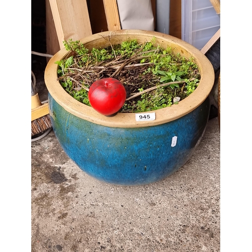 A large vibrant ceramic planter, boasting a rich blue glaze, perfect for adding a splash of color to any outdoor space.