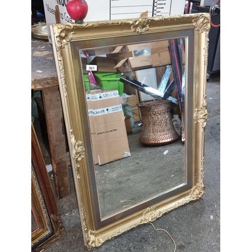 961 - Elegant gilt-framed mirror, with ornate floral and scroll motifs, enhancing any classic interior.