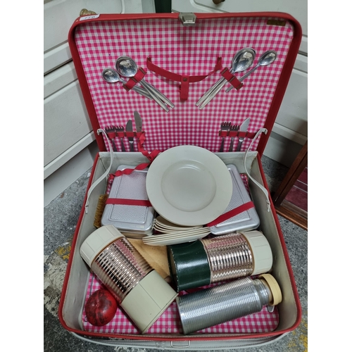 770 - A charming 1960s picnic set housed in a hard shell red case which includes stainless boxes  and stai... 