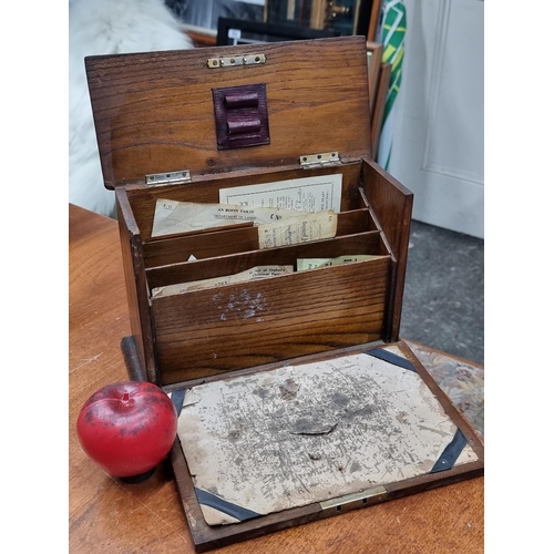 775 - A fantastic antique oak desk organizer featuring writing slope and dividers which contain an interes... 