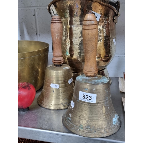 823 - A pair of large vintage brass school bells with solid wooden handles.