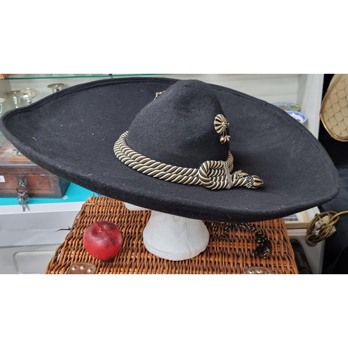 840 - A very large, heavy very good quality  Mexican sombrero. With gold and black tassel chin strap.