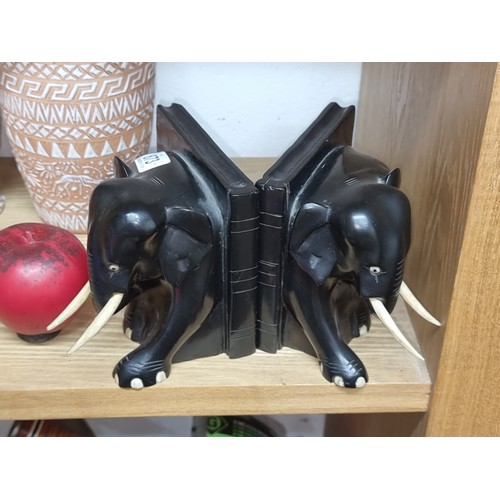 873 - A pair of vintage black ebony elephant book ends with real bone tusks and feet.