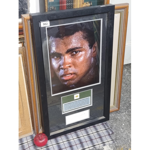 902 - Star Lot : A framed display boasting the authentic signature of Muhammed Ali, along with a fragment ... 