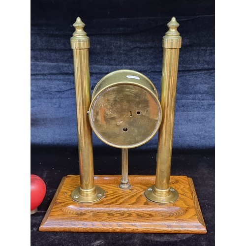 217 - A gorgeous and rare mid century brass table clock featuring two columns with finials to top sat on a... 