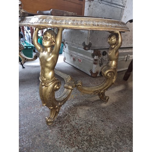 617 - A vintage coffee table with gilt border and legs in the form of people supporting the table with scr... 