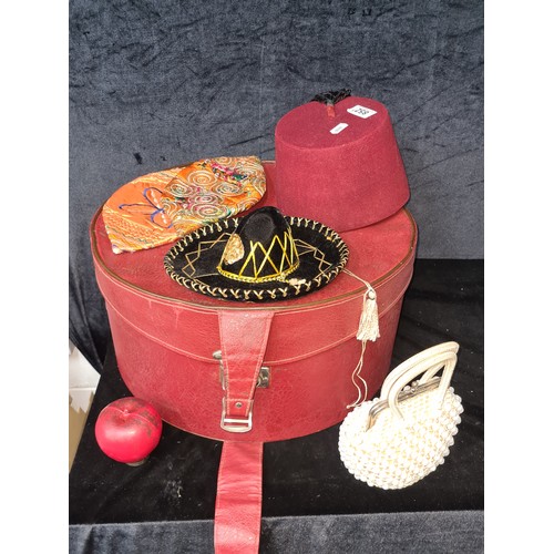 852 - A red vintage hat box with a vintage red fez hat etc.