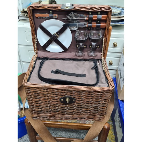 809 - A wonderful wicker picnic basket comprising of a fine selection of plates, cutlery, glasses and a fl... 