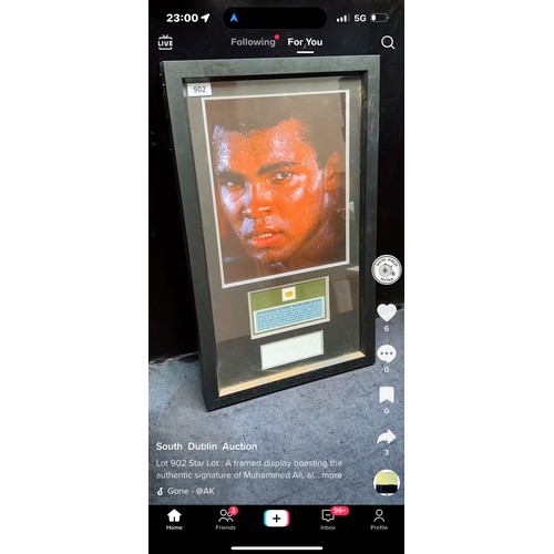 902 - Star Lot : A framed display boasting the authentic signature of Muhammed Ali, along with a fragment ... 