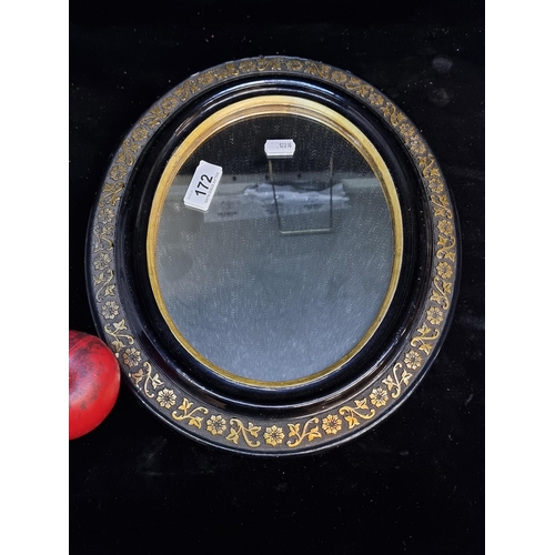 172 - A really charming early 20th century oval mirror. Features floral black and gilt frame.