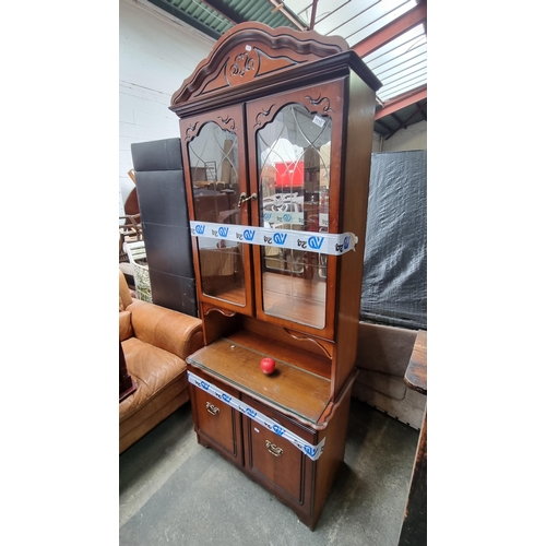 1110 - A beautiful vintage display cabinet featuring two glass fronted doors and two storage cupboards as w... 