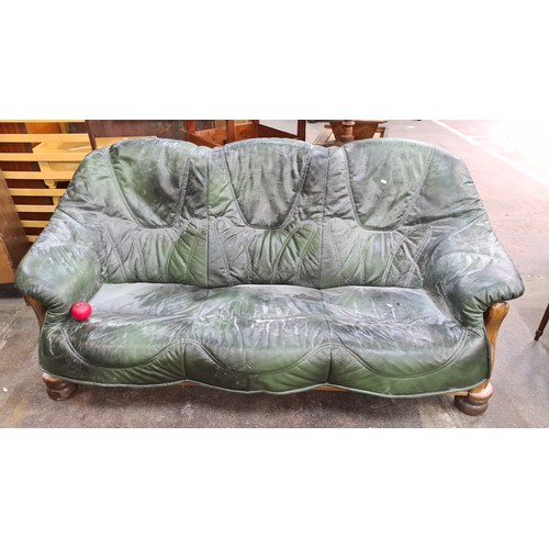 1112 - A fabulous oak three seater vintage sofa complete with green leather seating. Features a bun feet an... 