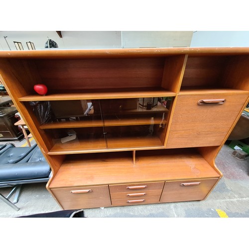 489 - Star Lot :A terrific Mid Century Teak display cabinet / bookcase. Features a fold down home bar spac... 