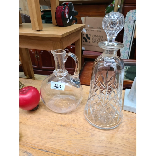 Two striking vintage glassware items including a whiskey decanter and a claret jug.