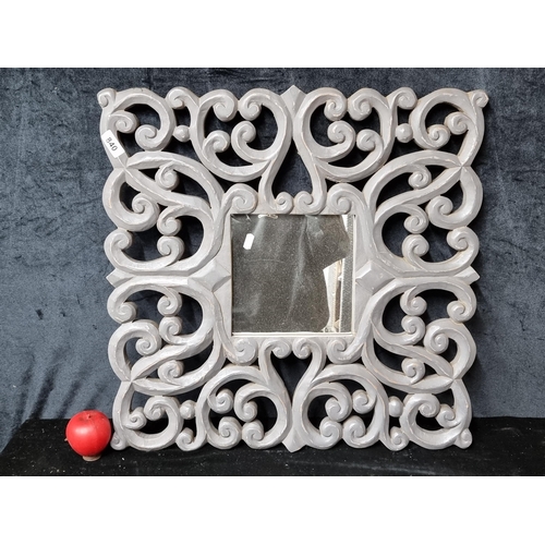 840 - An elaborately carved wood framed mirror in French grey finish.