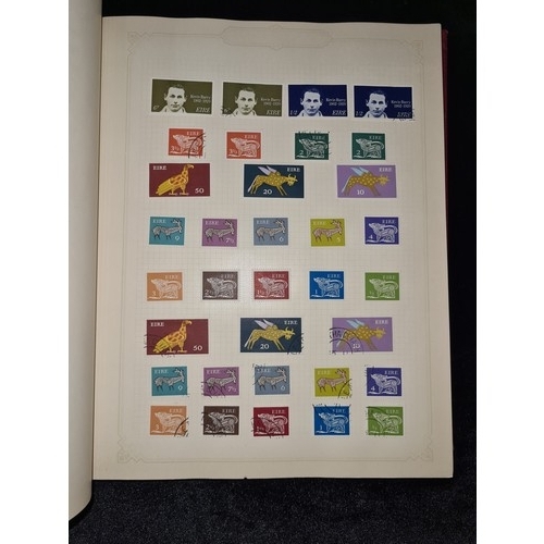 796 - Star Lot : Vintage red stamp album featuring a selection of early Irish Free State stamps. Including... 