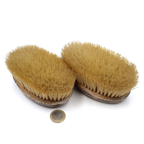 43 - A pair of sterling silver topped clothes brushes. Brushes in good order. Dimensions 12cm x7cm.