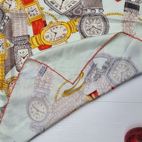 411 - Star Lot : A Cartier silk scarf depicting the companies various watch designs with rolled stitched e... 