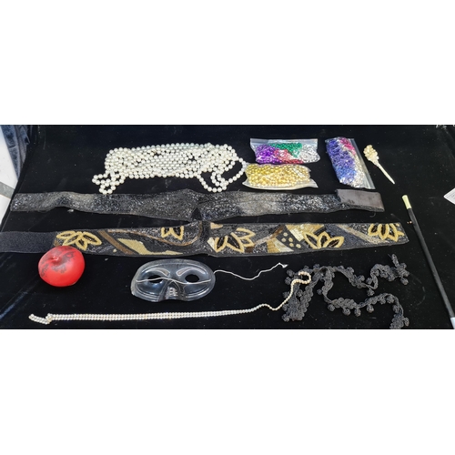 172 - A clear box containing costume jewellery including beaded necklaces and a cigarette holder and a mag... 