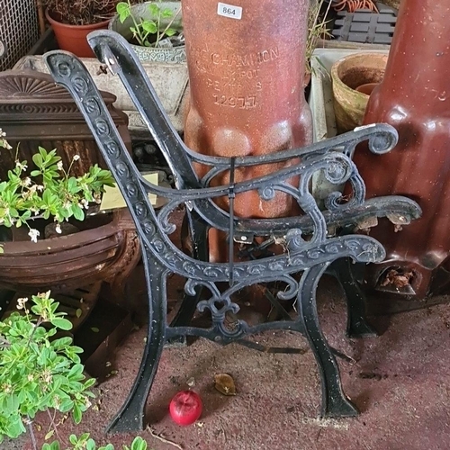 869 - A decorative cast iron garden bench frames with intricate scrollwork and heart motif.