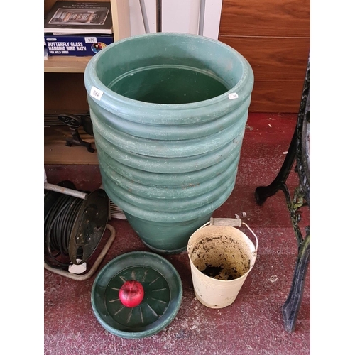 884 - A selection of gardening accessories including eight large green pots with seven matching saucer, al... 