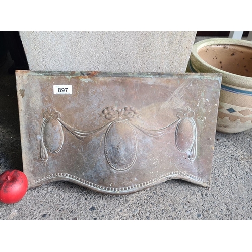 897 - An antique embossed hand hammered Arts & Crafts fireplace cover with decorative drapery motifs, late... 