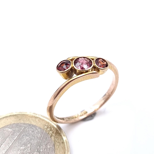 909 - A nine carat gold three stone garnet ring. Size - K. Weight - 1.62 grams.