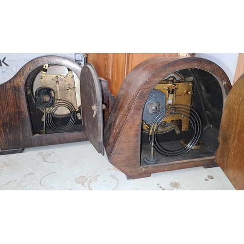 934 - A pair of classic vintage mantel clocks featuring wooden cases with scrollwork accents.