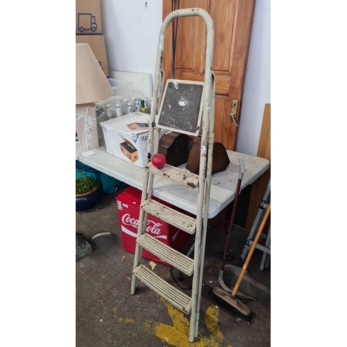 935 - A vintage metal step ladder with a high handle, providing stable support and utilitarian charm.