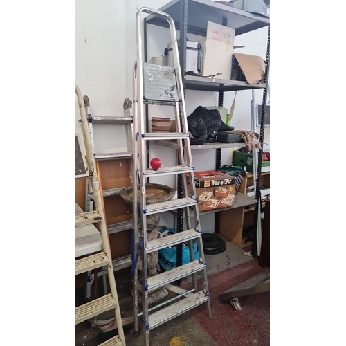 936 - A tall sturdy aluminum step ladder, lightweight and easy to store.