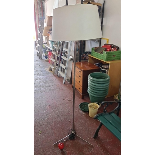 942 - An elegant tall Mid-century modern floor lamp with a minimalist design and a circular base, compleme... 