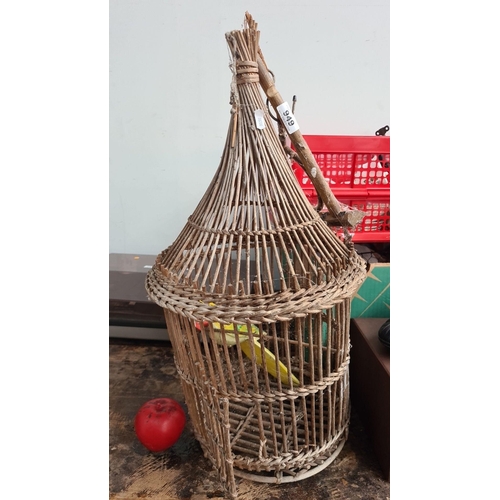 949 - Vintage wicker birdcage with a hand-painted wooden parrot; a charming decorative piece.