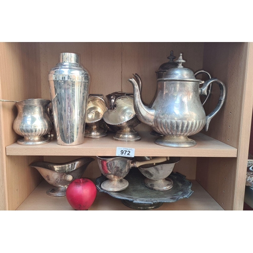 972 - A mixed lot of silver-plated items, including a cocktail shaker, teapot, and assorted bowls. Two she... 