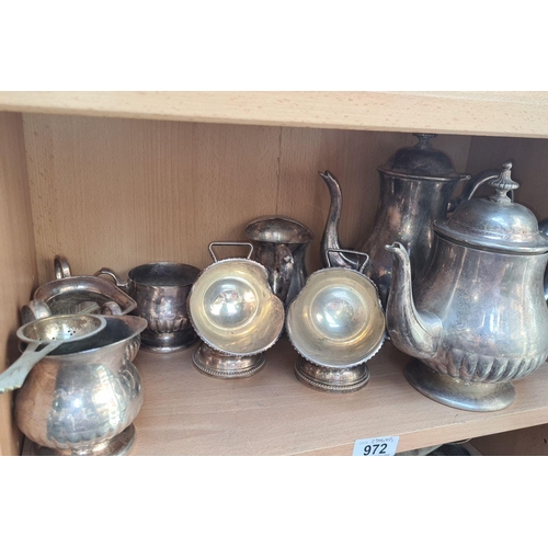 972 - A mixed lot of silver-plated items, including a cocktail shaker, teapot, and assorted bowls. Two she... 