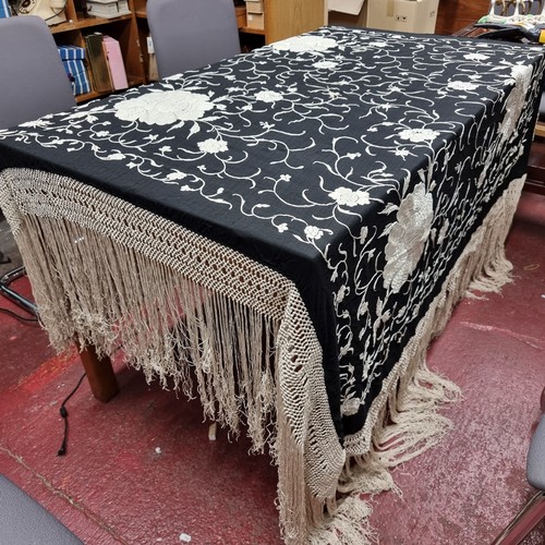 173 - A beautiful piano black cloth cover featuring a contrasting stitch of floral accents and fringe deta... 