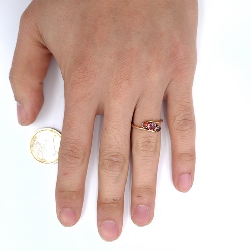 909 - A nine carat gold three stone garnet ring. Size - K. Weight - 1.62 grams.