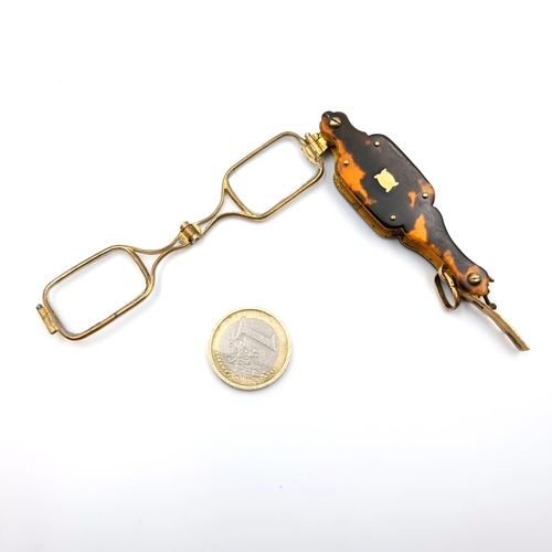 33 - An unusual pair of brass framed folding spectacles set in a faux tortoise shell mount. Length - 7 cm... 