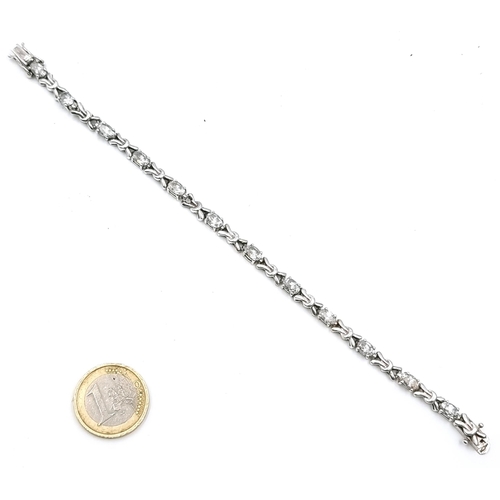 51 - A silver tennis bracelet with gemstone detailing set with double clasps. Weight - 13.7 grams.