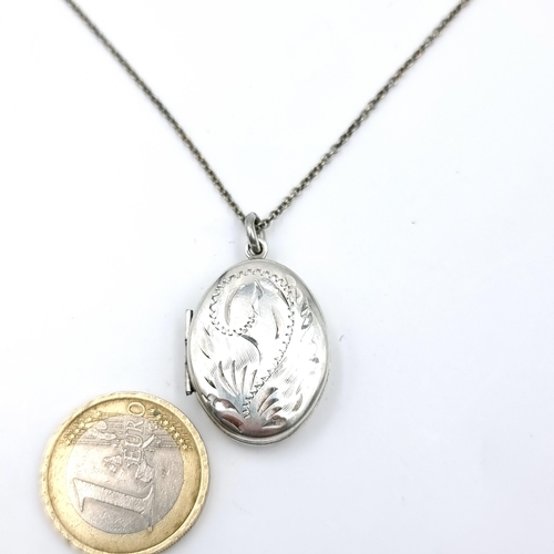 56 - A vintage sterling silver locket with floral detailing together with chain. Length - 50 cms. Weight ... 