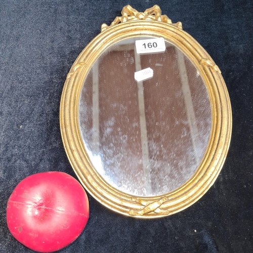 160 - A beautiful vintage small oval mirror with gilt gold frame featuring nice detailing.